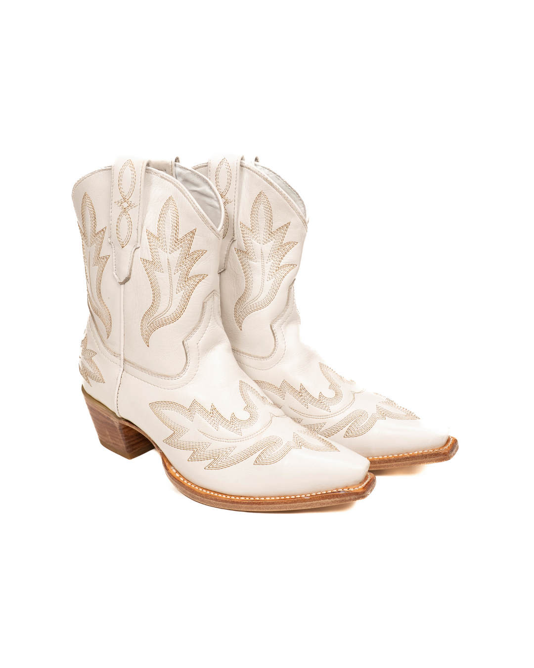 Pair of white cowboy boots with intricate designs